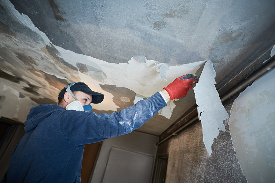 fire damage restoration - professional removes ruined paint layer from the charred ceiling - Belleville, IL